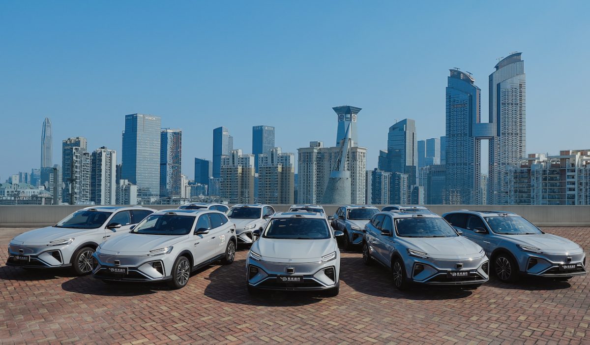 A fleet of vehicles parked in front of a city